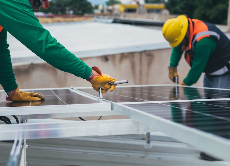 operai che installano pannelli fotovoltaici per produrre energia rinnovabile per la casa